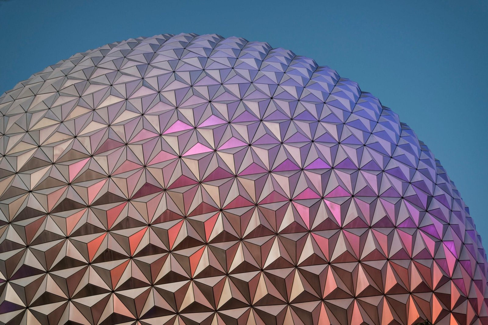 Close-up of a geodesic dome with vibrant colors reflecting at sunset.